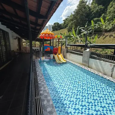 a swimming pool with a slide and an umbrella at 50PAX 9BR Villa Kids Swimming Pool, KTV, BBQ n Pool Tables near SPICE Arena Penang 9800 SQFT in Bayan Lepas
