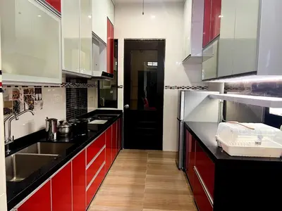 a kitchen with red cabinets and a black counter top at 50PAX 9BR Villa Kids Swimming Pool, KTV, BBQ n Pool Tables near SPICE Arena Penang 9800 SQFT in Bayan Lepas