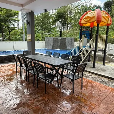 a table with chairs and an umbrella next to a pool at 18PAX 4BR Villa with Kids Swimming Pool, KTV, BBQ near SPICE Arena Penang in Bayan Lepas