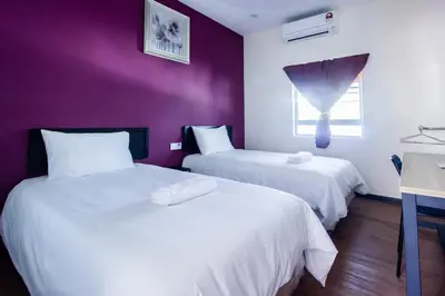 two beds in a room with purple walls at Explore 5BR Gardenhouse Retreats (Free Parking) in Butterworth