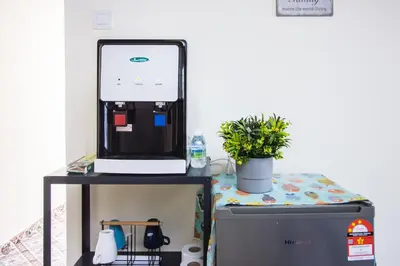 a coffee maker on a stand next to a refrigerator at Explore 5BR Gardenhouse Retreats (Free Parking) in Butterworth