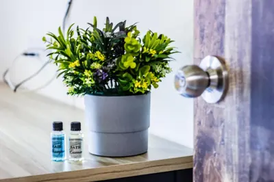a vase with flowers on a shelf next to a door at Explore 4BR Gardenhouse Retreats (Free Parking) in Butterworth
