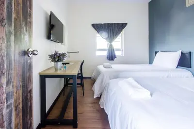 a room with two beds and a table and a window at Explore 4BR Gardenhouse Retreats (Free Parking) in Butterworth