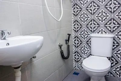 a bathroom with a white toilet and a sink at Explore 4BR Gardenhouse Retreats (Free Parking) in Butterworth