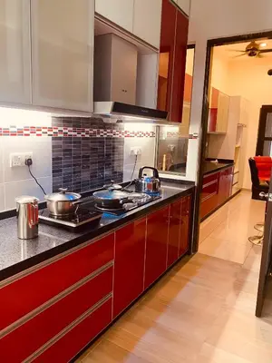 a kitchen with red cabinets and a stove top oven at 30PAX 7BR Villa with Kids Swimming pool, KTV, Pool Table n BBQ near SPICE Arena Penang 9800 SQFT in Bayan Lepas
