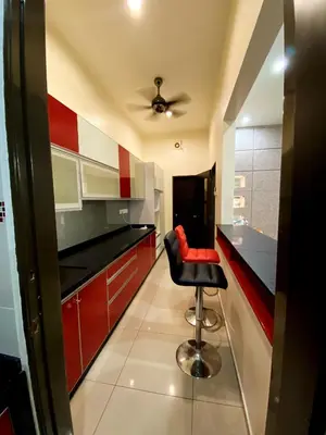 a kitchen with a black counter and a red stool at 40 PAX 9BR Villa with Kids swimming Pool, KTV, BBQ n Pool Tables near SPICE Arena Penang 9800 SQFT in Bayan Lepas