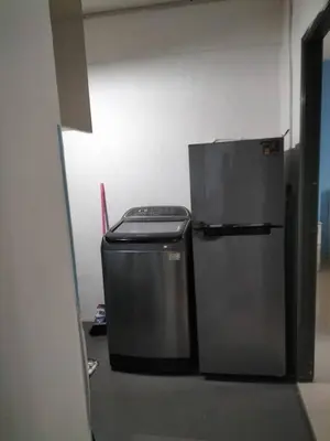 a refrigerator and a trash can in a room at Homestay pangsapuri sutera seberang jaya in Kampong Telok
