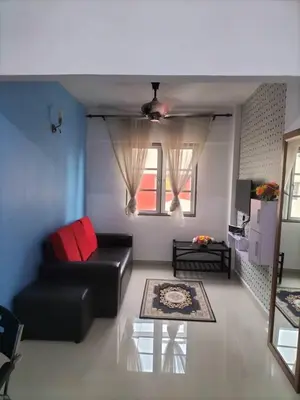 a living room with a black couch and a window at Homestay pangsapuri sutera seberang jaya in Kampong Telok