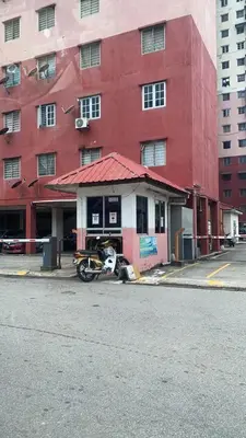 a motorcycle parked in front of a red building at Homestay pangsapuri sutera seberang jaya in Kampong Telok