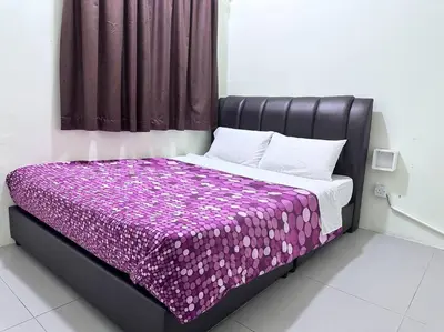 a bed in a room with a purple blanket at #CameronHighlands homestay in Brinchang