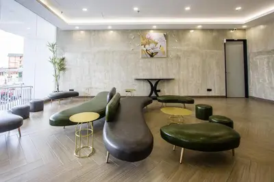 a waiting room with green chairs and tables at Sri Indar Hotel & Suites in Parit Buntar