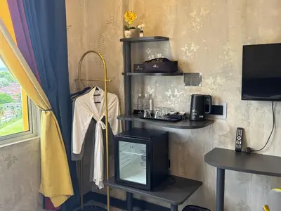 a room with a television and a shelf with a tv at Sri Indar Hotel & Suites in Parit Buntar