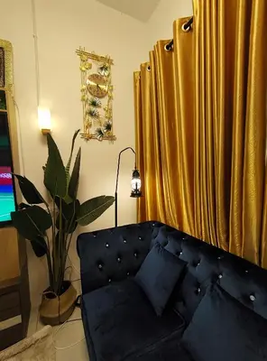 a living room with a couch and a yellow curtain at HOMESTAY SYAABAN Kamunting Taiping Batu Kurau Ulu Sepetang in Kamunting