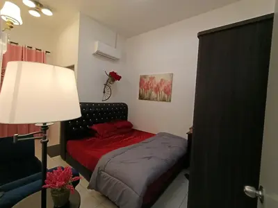 a small bedroom with a bed and a lamp at HOMESTAY SYAABAN Kamunting Taiping Batu Kurau Ulu Sepetang in Kamunting
