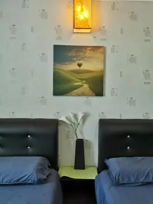 a bedroom with two beds and a picture on the wall at C 13 Lot 10 Pangkor Leisure Beach Studio in Pangkor
