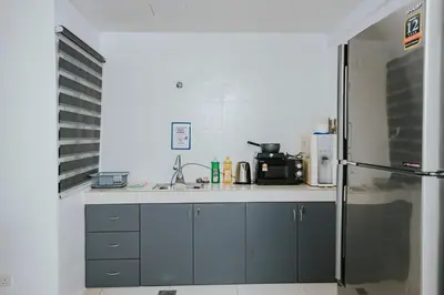 a kitchen with a sink and a refrigerator at Ipoh Manhattan Premium Suites by Verve in Ipoh