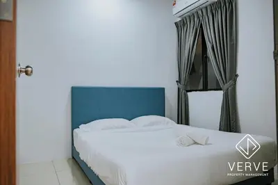 a bedroom with a white bed with a blue headboard at Ipoh Manhattan Premium Suites by Verve in Ipoh