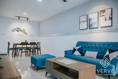 a living room with a blue couch and a table at Ipoh Manhattan Premium Suites by Verve in Ipoh
