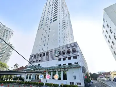 a tall white building with a clock on it at Mansion One Suite by stayCATion Homestay in George Town
