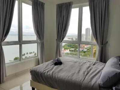 a bedroom with windows and a bed with a view at Mansion One Suite by stayCATion Homestay in George Town