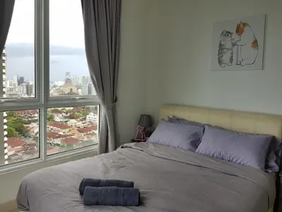 a bed in a bedroom with a large window at Mansion One Suite by stayCATion Homestay in George Town