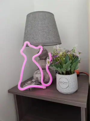 a table with a lamp and a pink sculpture on it at Mansion One Suite by stayCATion Homestay in George Town