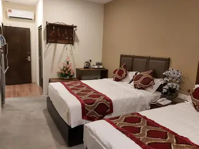 a hotel room with two beds and a door at KB HOTEL in Kepala Batas