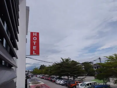 a sign on the side of a building with parked cars at KB HOTEL in Kepala Batas