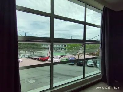 a window with a view of a parking lot with a plane at KB HOTEL in Kepala Batas