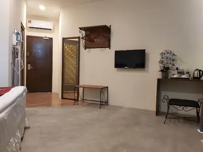 a living room with a couch and a tv on the wall at KB HOTEL in Kepala Batas
