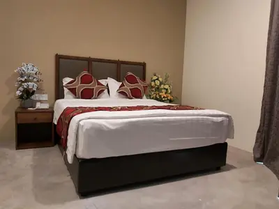 a bedroom with a large bed with red and white pillows at KB HOTEL in Kepala Batas