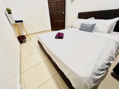 a bed with white sheets and purple shoes on it at Cozy 288 Entire 3 bedroom House @ Alma Bukit Mertajam in Bukit Mertajam