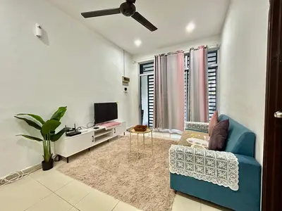 a living room with a blue couch and a tv at Cozy 288 Entire 3 bedroom House @ Alma Bukit Mertajam in Bukit Mertajam
