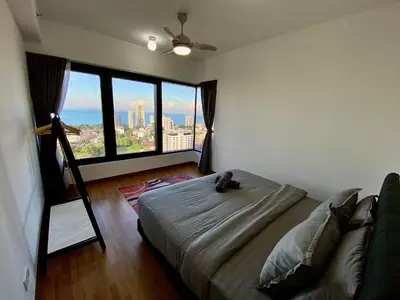 a bedroom with a bed and a large window at Tropicana 218 Macalister Sea & City View by stayCATion Homestay in George Town