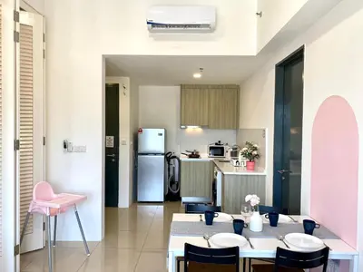 a kitchen and dining room with tables and pink chairs at Tropicana 218 Macalister Sea & City View by stayCATion Homestay in George Town