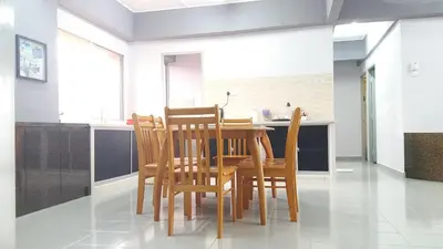 a dining room with a wooden table and chairs at Coastside Homestay in George Town