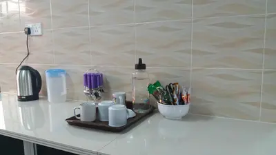 a counter with a tray with cups and pens at Coastside Homestay in George Town