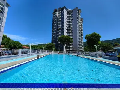 a swimming pool with a tall building in the background at Coastside Homestay in George Town
