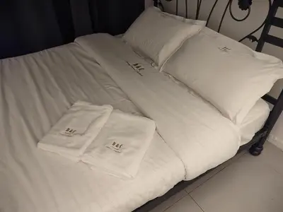 a bed with white sheets and white pillows on it at D&C Homestay A Modern Forest Boutique in Brinchang