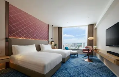 a hotel room with two beds and a flat screen tv at Amari SPICE Penang in Bayan Lepas
