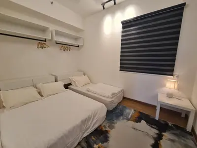 a white bedroom with a bed and a window at Beacon Executive Premium Suite in George Town
