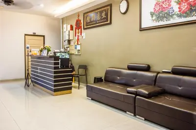 a waiting room with a leather couch and a counter at Value Inn Homestay in Butterworth