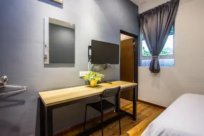 a room with a desk with a computer and a bed at Surprised Homestay Butterworth in Butterworth