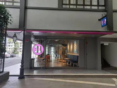 a restaurant with a pink sign in front of a building at Hotel COOL MAMA in Brinchang