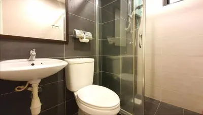 a bathroom with a toilet and a sink and a shower at Kinta River Front Suites Ipoh by Beestay in Ipoh