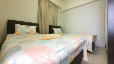 two beds sitting next to each other in a bedroom at Kinta River Front Suites Ipoh by Beestay in Ipoh