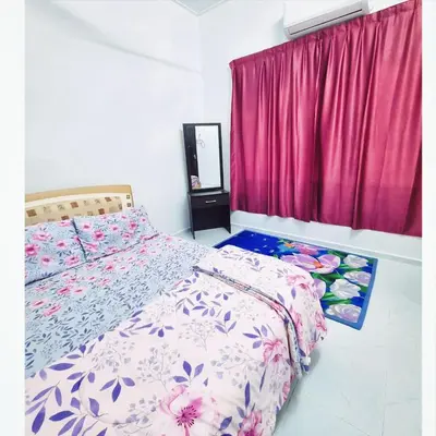 a bedroom with a bed and a pink curtain at HomeStay with Serene Surrounding in Nibung Tebal