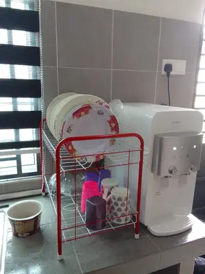 a drying rack in a kitchen next to a white appliance at HOMESTAY IMPIAN, BATU GAJAH PERAK in Kampong Paya Rengas