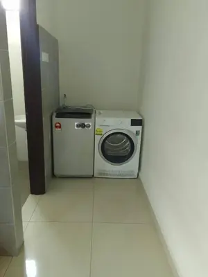 a washer and dryer sitting in a bathroom at HOMESTAY IMPIAN, BATU GAJAH PERAK in Kampong Paya Rengas