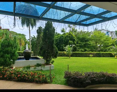 a garden with a fountain and flowers in a park at Seri Sayang Seaview Resort Batu Ferringhi in Batu Ferringhi
